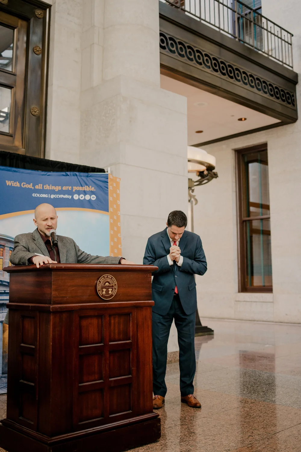 Praying, one at the microphone and one beside it