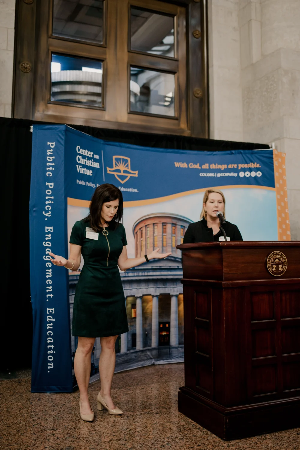 Two women praying at the podium